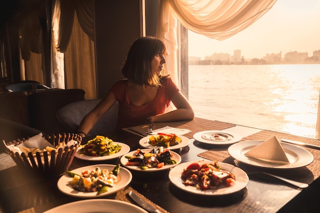 Een jonge toerist die op een boot op de Nijl dineert met een traditionele Egyptische maaltijd