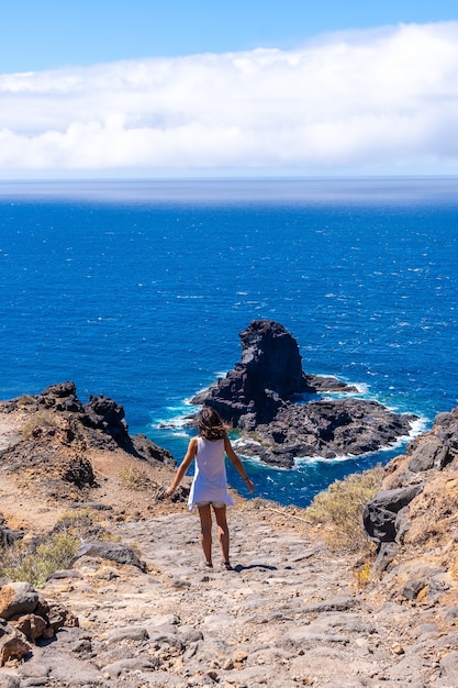 Een jonge toerist die over het klifpad loopt op de afdaling naar het zwarte zandstrand van Bujaren, ten noorden van het eiland La Palma, Canarische Eilanden. Spanje