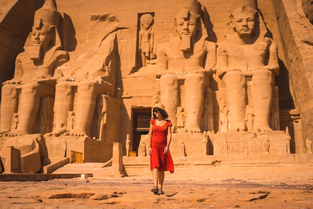 Een jonge toerist in een rode jurk die de Abu Simbel-tempel verlaat