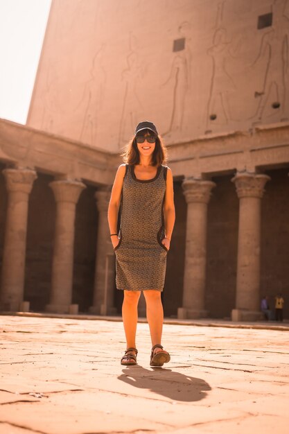 Een jonge toerist met een pet die de edfu-tempel bezoekt bij zonsopgang in aswan. egypte