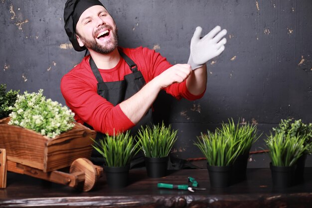 Een jonge tuinman zorgt voor zaailingen en snijdt bloemenTuinman met een bloembak Man die zorgt voor het planten van zaailingen in het voorjaar