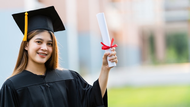 Een jonge universitair afgestudeerde is in het bezit van een diploma