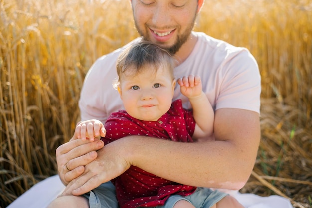 Een jonge vader en zijn zoon zitten in de zomer in het veld in de natuur