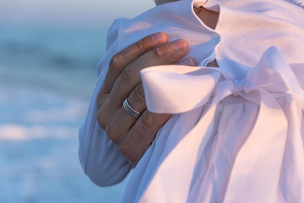 Een jonge vader met een dochtertje loopt langs het zeestrand in de zonsondergang