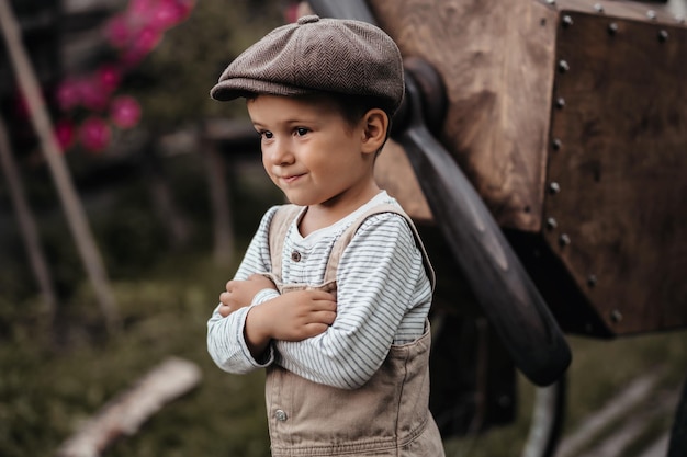 Een jonge vliegerjongen in de buurt van de propeller van een zelfgemaakt vliegtuig in een natuurlijk landschap Close-up Geeft de foto een authentieke sfeer Vintage