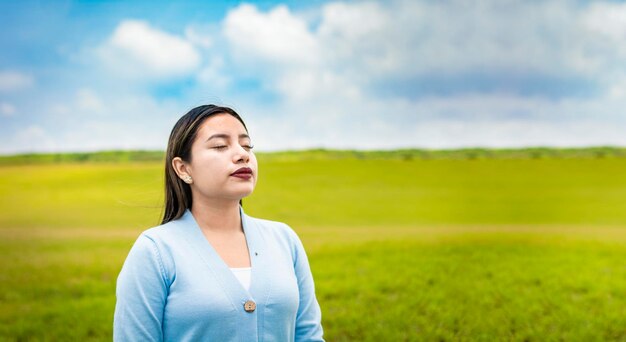 Een jonge vrouw die diep in het veld ademt Een jong meisje dat frisse lucht in het veld inademt Jonge vrouw die 's ochtends frisse lucht in het veld inademt