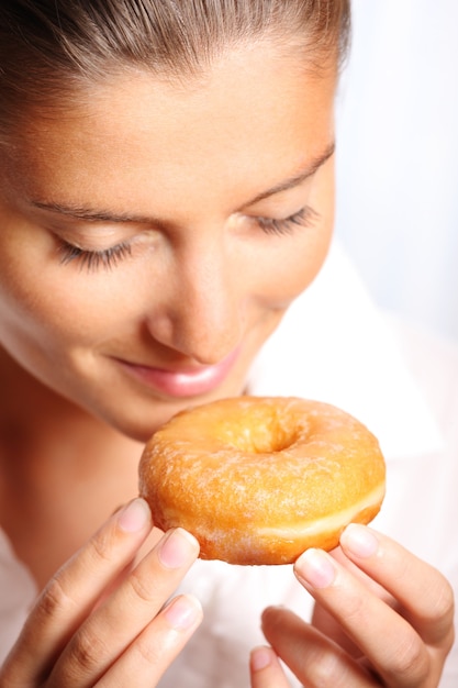 een jonge vrouw die een donut vasthoudt