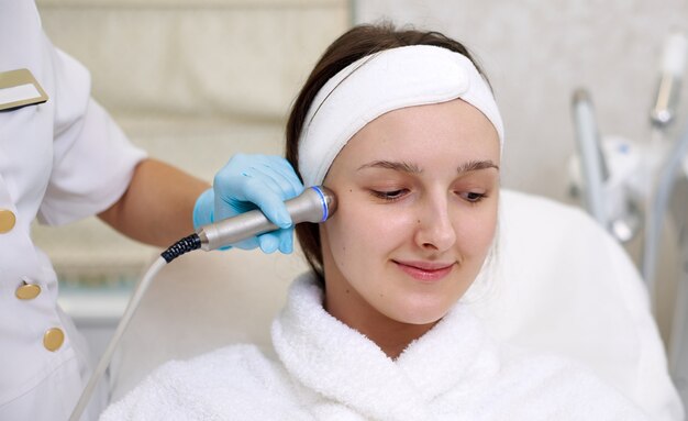 Een jonge vrouw die een gezichtsverjonging ontvangt. Facial Hydro Microdermabrasion Peeling-behandeling