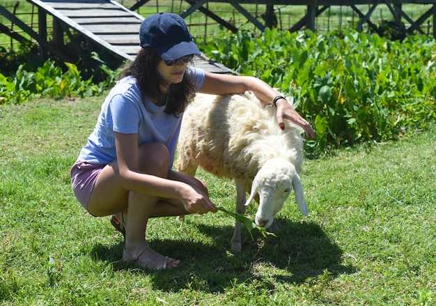 Een jonge vrouw die een schaap aait op een Vietnamese boerderij