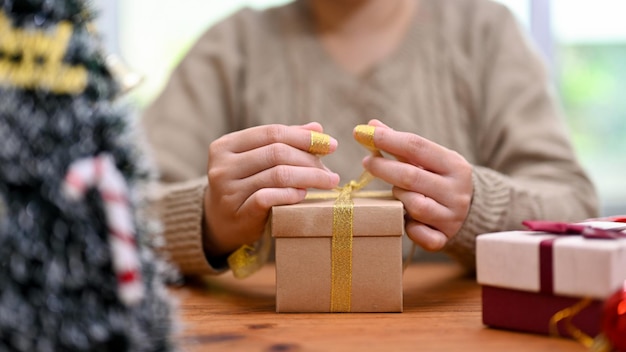 Een jonge vrouw die haar kerstcadeau inpakt in een doos die een kerstverrassingscadeau inpakt