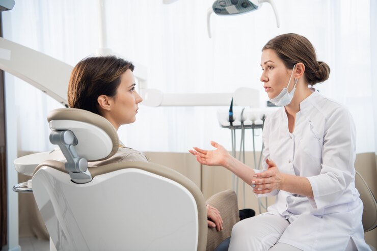 Een jonge vrouw die klaagt bij haar tandarts in de tandheelkundige kliniek