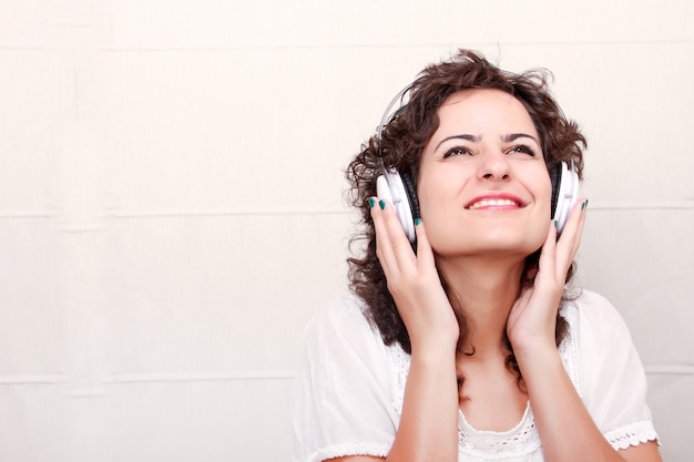 Een jonge vrouw die muziek met hoofdtelefoons luistert.