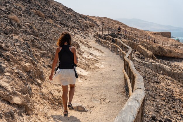 Een jonge vrouw die op het pad loopt in de Cuevas de Ajuy, Pajara, westkust van het eiland Fuerteventura, Canarische Eilanden. Spanje