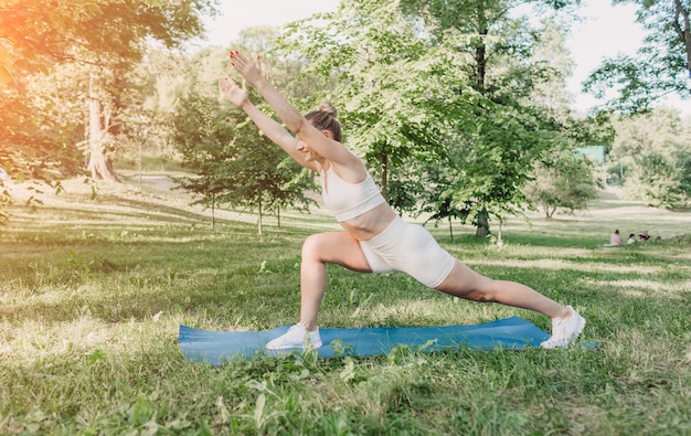 Een jonge vrouw die 's ochtends bij zonsopgang buiten yoga beoefent, een gezonde levensstijl