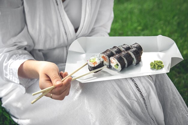 Een jonge vrouw die sushi eet in de close-up van het makibroodje van de natuur