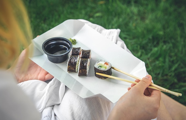 Een jonge vrouw die sushi eet in de close-up van het makibroodje van de natuur