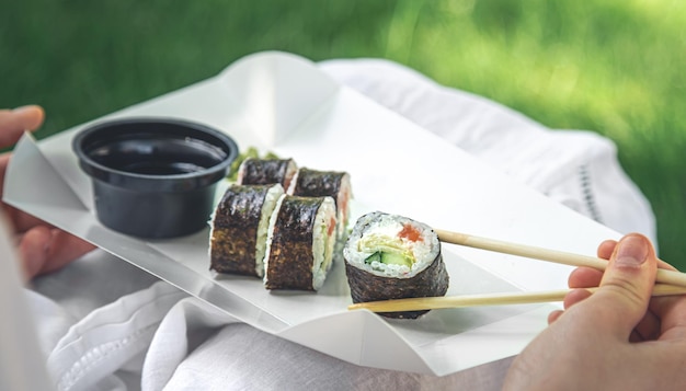 Een jonge vrouw die sushi eet in de close-up van het makibroodje van de natuur