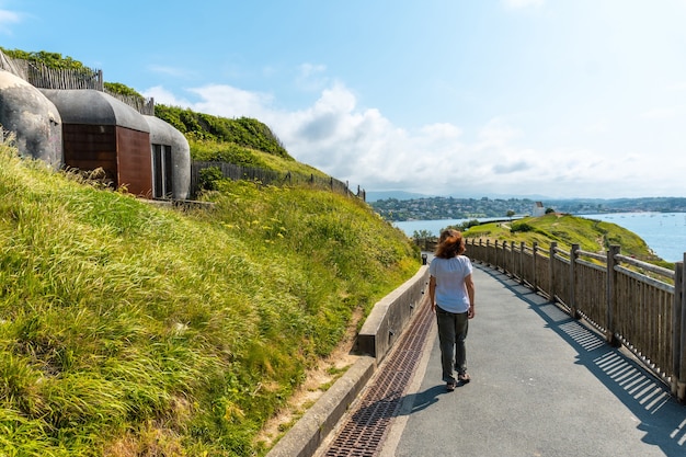 Een jonge vrouw die tussen de bunkers van de Wereldoorlog loopt in het natuurpark van Saint Jean de Luz genaamd Parc de Sainte Barbe, Col de la Grun in het Franse Baskenland