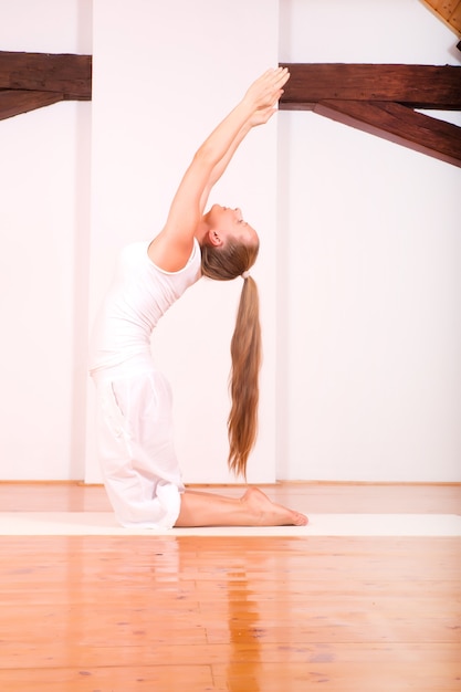 Een jonge vrouw die yoga beoefent in een zolderstudio.