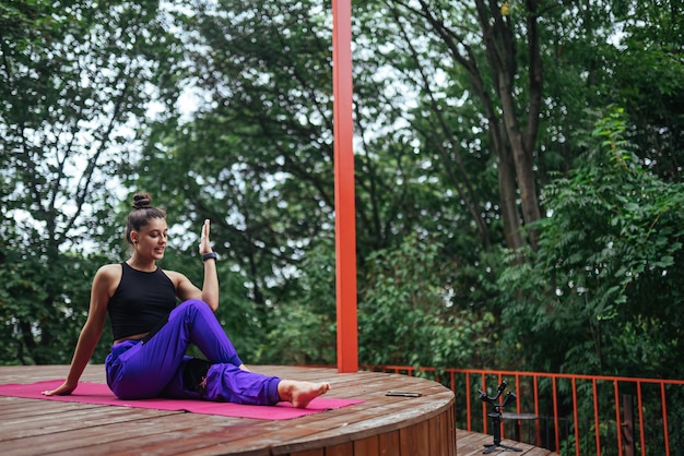 Een jonge vrouw die yoga doet in de tuin