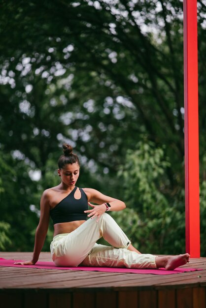 Een jonge vrouw die yoga doet in de tuin