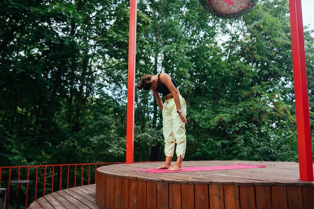 Een jonge vrouw die yoga doet in de tuin