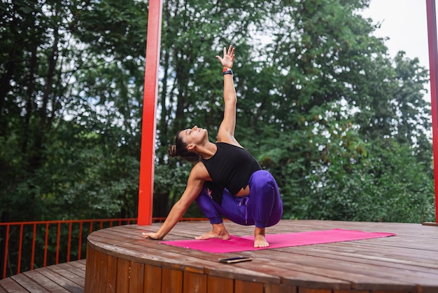 Een jonge vrouw die yoga doet in de tuin