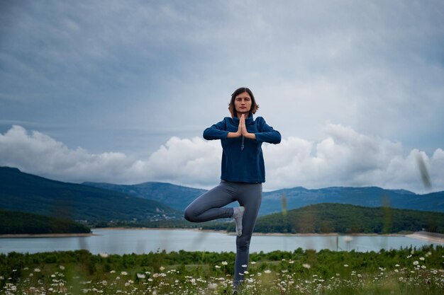 Een jonge vrouw die yoga doet in het veld