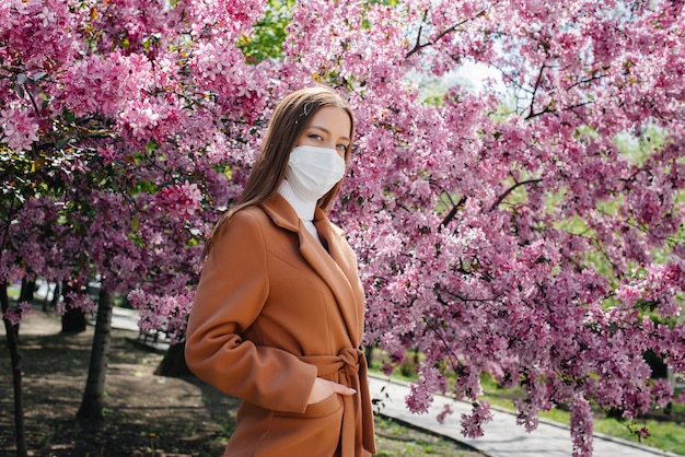 Een jonge vrouw doet haar masker af en haalt diep adem na het einde van de pandemie op een zonnige lentedag