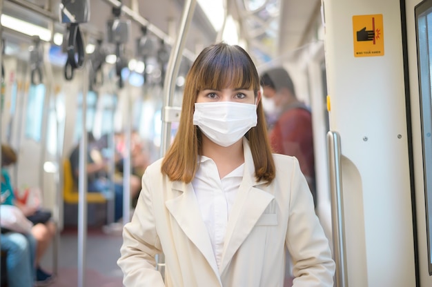 Een jonge vrouw draagt een beschermend masker in de metro, covid-19-bescherming, veiligheidsreizen, nieuw normaal, sociale afstand, veiligheidsvervoer, reizen onder pandemisch concept