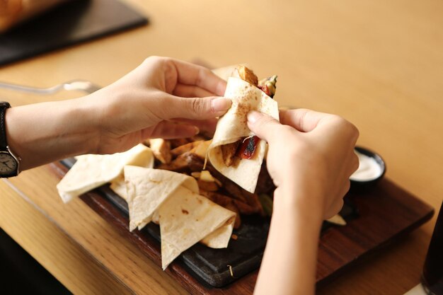 Een jonge vrouw eet een smakelijke verse Indiase maaltijd