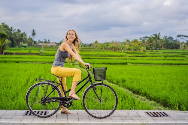 Een jonge vrouw fietst op een rijstveld in Ubud Bali Bali Travel Concept