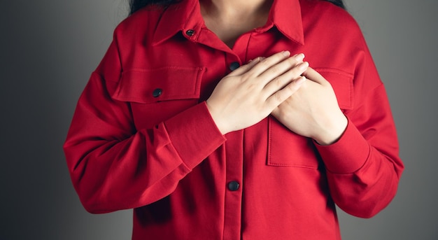 Een jonge vrouw houdt handen op haar borst