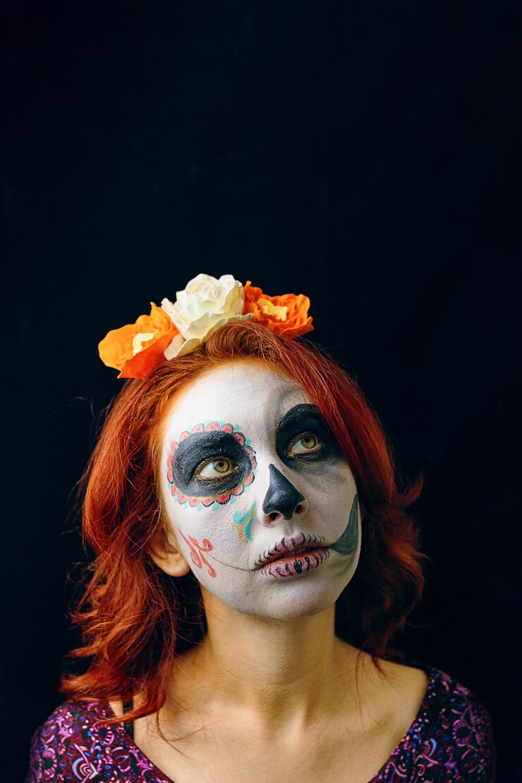 Een jonge vrouw in de dag van de doden masker schedel gezicht kunst vrouw met halloween schedel make-up over zwarte b...