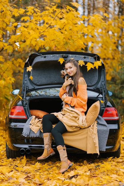 Een jonge vrouw in een auto op de kofferbak