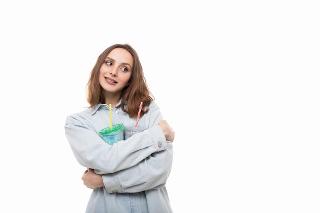 Een jonge vrouw in een bezit twee glanzende cocktailglazen op een witte achtergrond