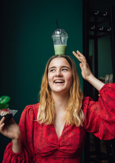 Een jonge vrouw in een café drinkt een groene drank ice latte