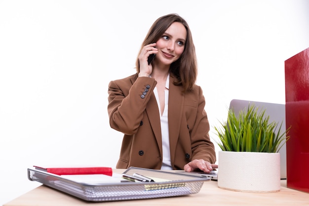 Een jonge vrouw in een pak praat aan de telefoon