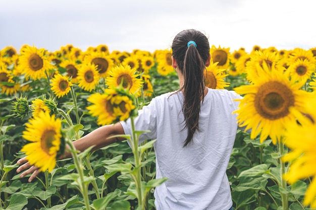 Een jonge vrouw in een veld met veel zonnebloemen