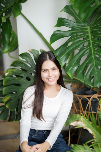 Een jonge vrouw in het wit kleedt portret met groene planten