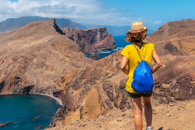 Een jonge vrouw in Ponta de Sao Lourenco kijkt naar het landschap en de zee Madeira kust Portugal