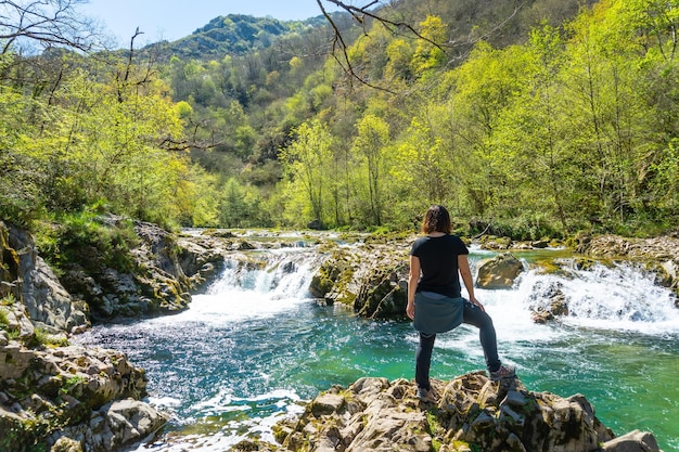 Een jonge vrouw kijkt naar de watervallen aan de rivier de Sella tussen El Tornin a la Olla de San Vicente in de buurt van Cangas de Onis Asturias, Spanje