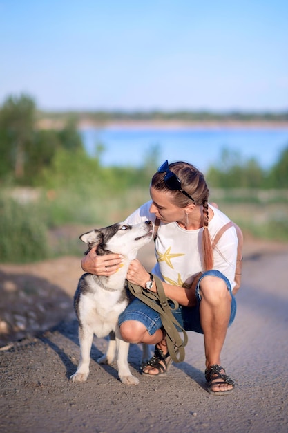 Een jonge vrouw knuffelt met haar Alaskan Cliquei-hond