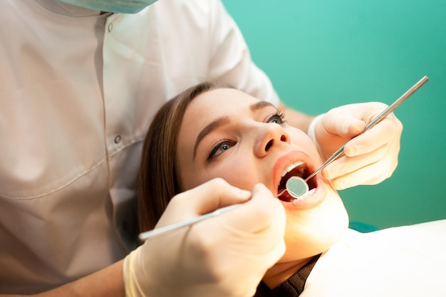 Een jonge vrouw kwam voor onderzoek naar de tandarts. De tandarts onderzoekt de patiënt van dichtbij