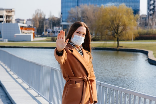 Een jonge vrouw loopt in een masker tijdens de pandemie en het coronovirus