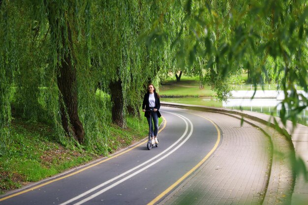 Een jonge vrouw loopt langs het pad voor een elektrische scooter in de moderne vervoerswijzen van de stad