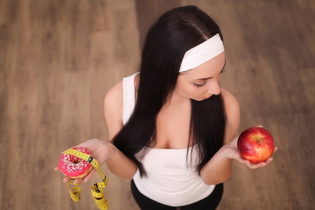 Een jonge vrouw met een donut en een meetlint