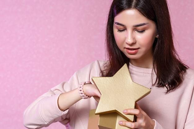 Een jonge vrouw met een giftdoos in haar handen