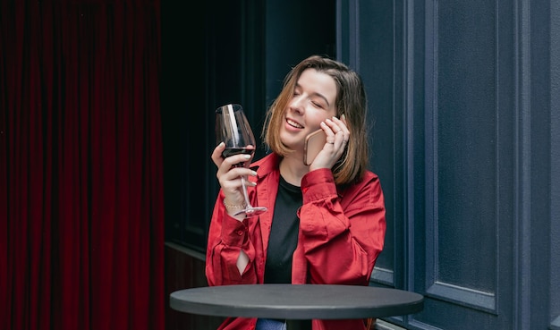 Een jonge vrouw met een glas wijn op het terras van een restaurant