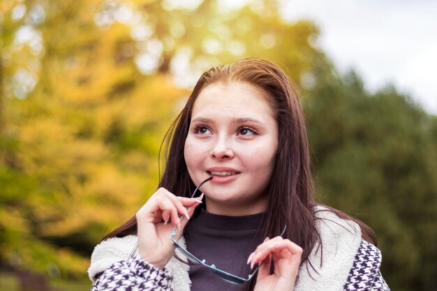 Foto een jonge vrouw met een glimlach op haar gezicht die haar zonnebril afzet, herinnert zich prettige momenten